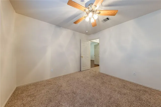 an empty room with chandelier fan
