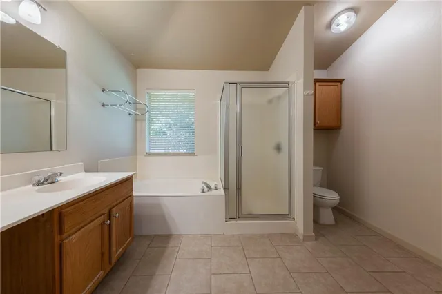 a spacious bathroom with a granite countertop sink toilet and shower