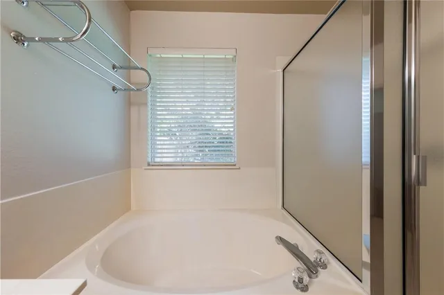 a white bath tub sitting in a bathroom next to a window