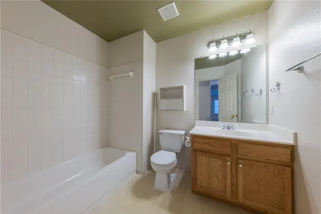 a bathroom with a sink a toilet and a large mirror