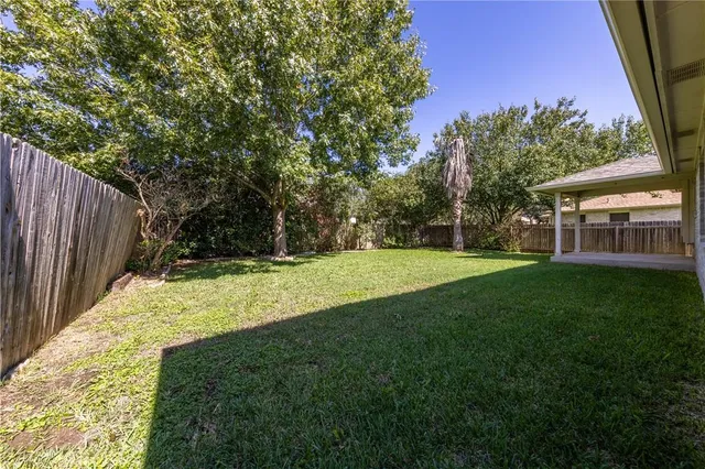 a view of a house with backyard and trees