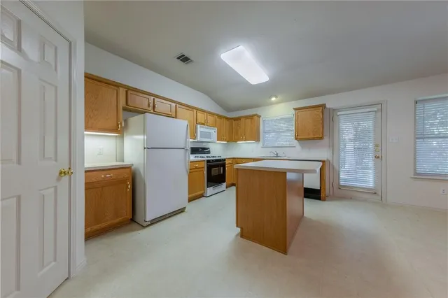 a kitchen with refrigerator cabinets and a sink