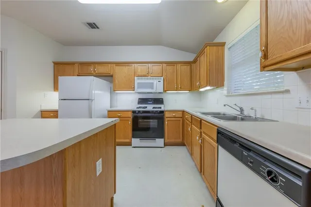 a kitchen with a sink a stove top oven and cabinets