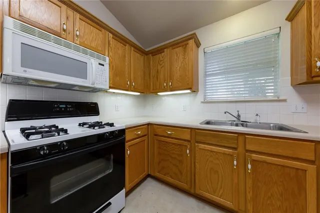 a kitchen with granite countertop cabinets stainless steel appliances and a window