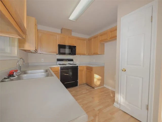 a kitchen with a sink a stove and cabinets