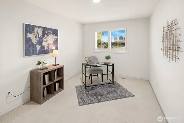 a view of a workspace with furniture and a window