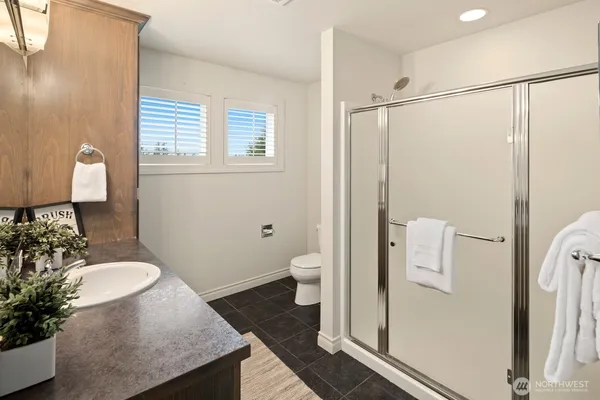 a bathroom with a granite countertop sink toilet and shower