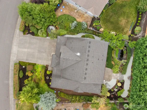 an aerial view of a residential house with a yard and garden