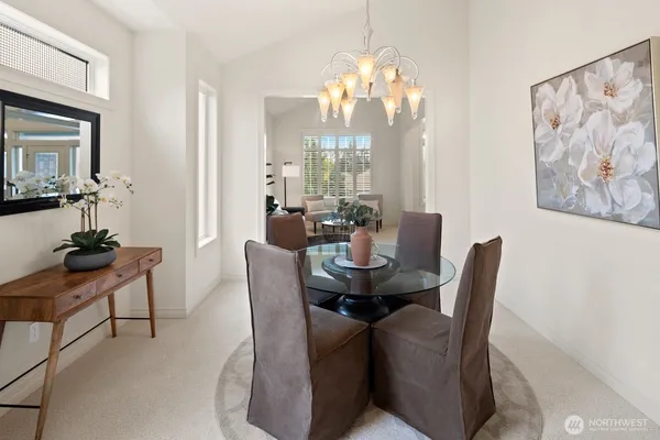 a dining room with furniture a chandelier and window