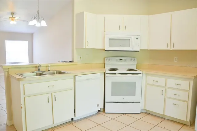 a kitchen with white cabinets appliances and sink