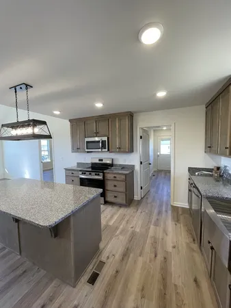 a kitchen with stainless steel appliances granite countertop a sink dishwasher stove and oven with wooden floor
