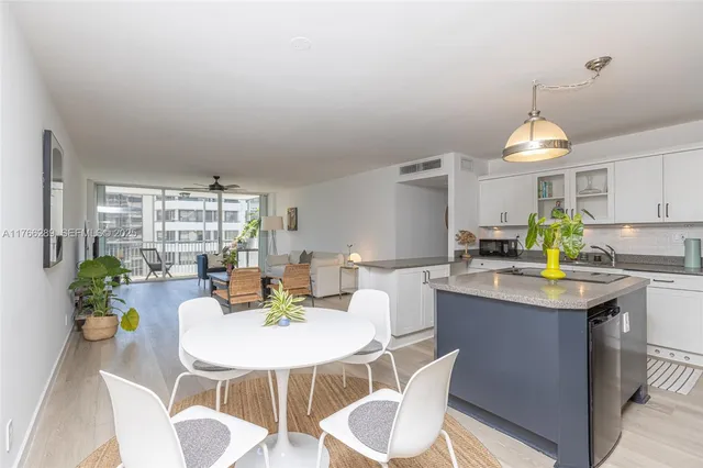 a kitchen with a dining table cabinets and wooden floor