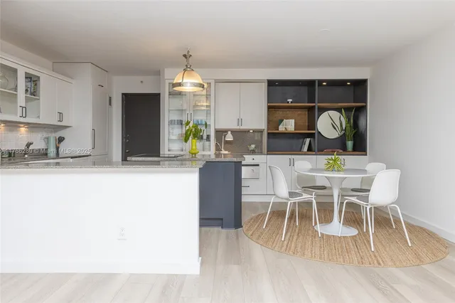a view of kitchen with wooden cabinets and dining table