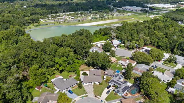 a view of a lake with a house a swimming pool and outdoor seating