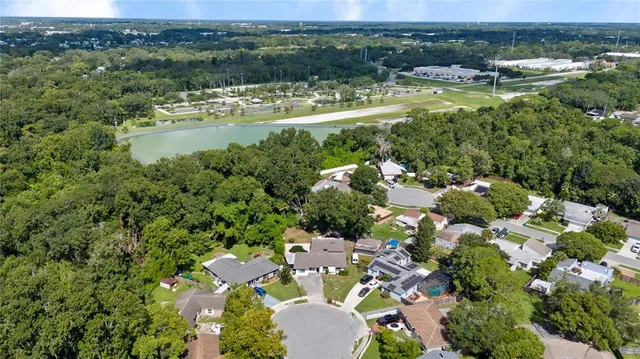 an aerial view of residential houses with outdoor space and lake view