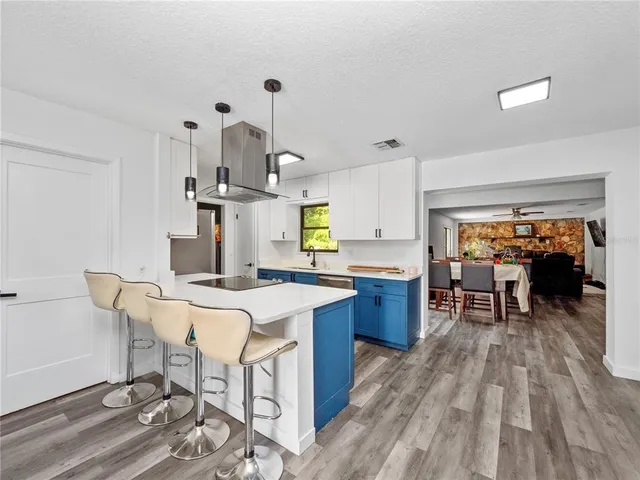 a kitchen with a sink a stove cabinets and wooden floor