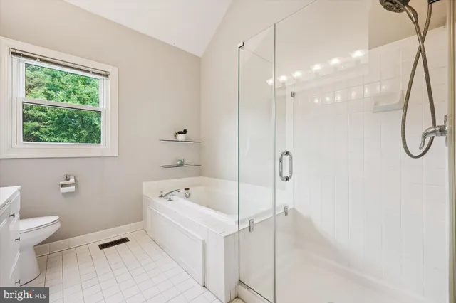 a bathroom with a tub a toilet and a shower