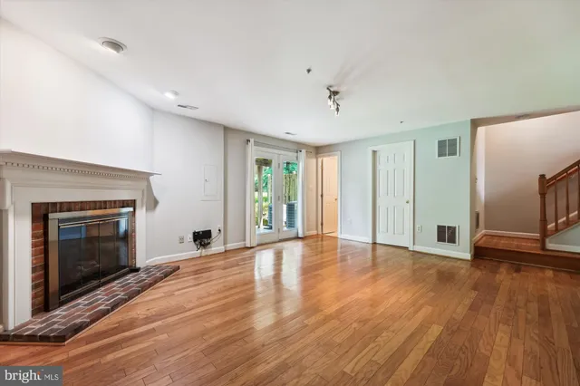 a view of empty room with wooden floor and fireplace