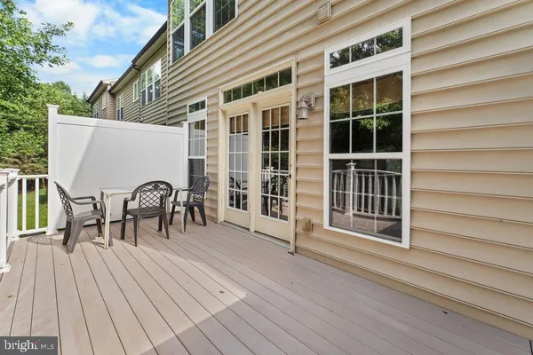 a view of a roof deck with table and chairs and wooden floor