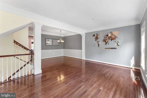 a view of a hallway with wooden floors and a window