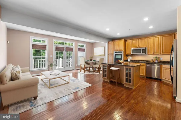 a living room with stainless steel appliances furniture and a large window