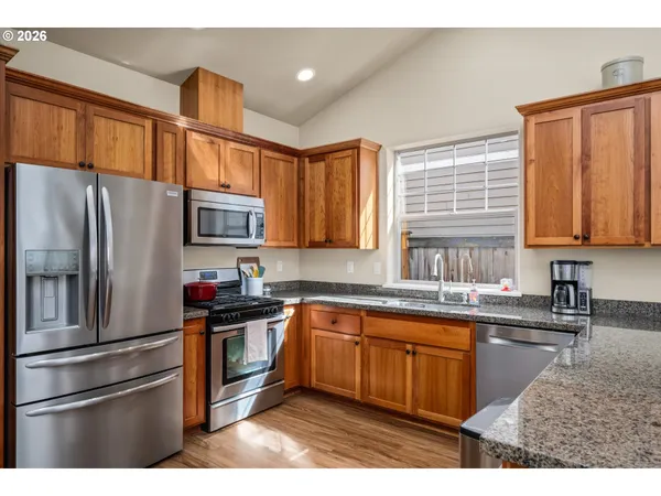 a kitchen with stainless steel appliances granite countertop a refrigerator sink and cabinets