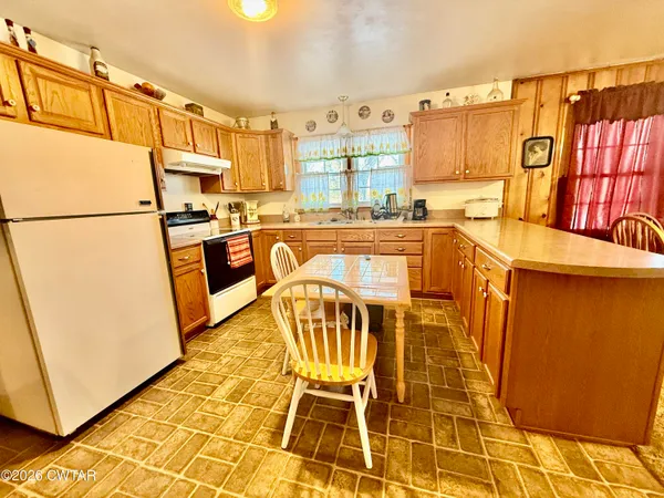 a kitchen with granite countertop a refrigerator a stove a sink and dishwasher