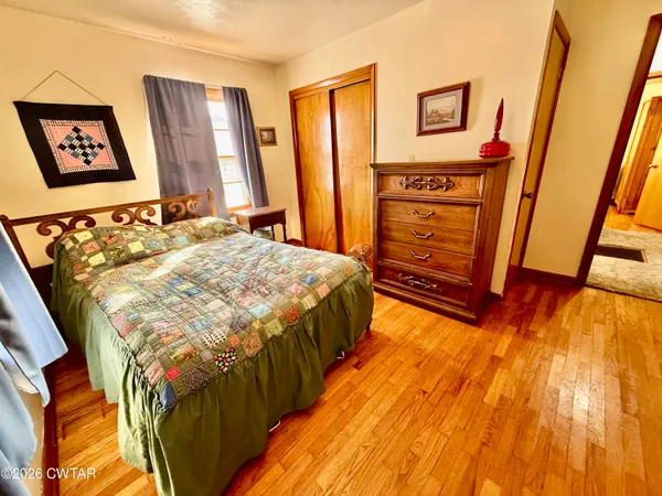 a bedroom with a bed and a flat tv screen on dresser