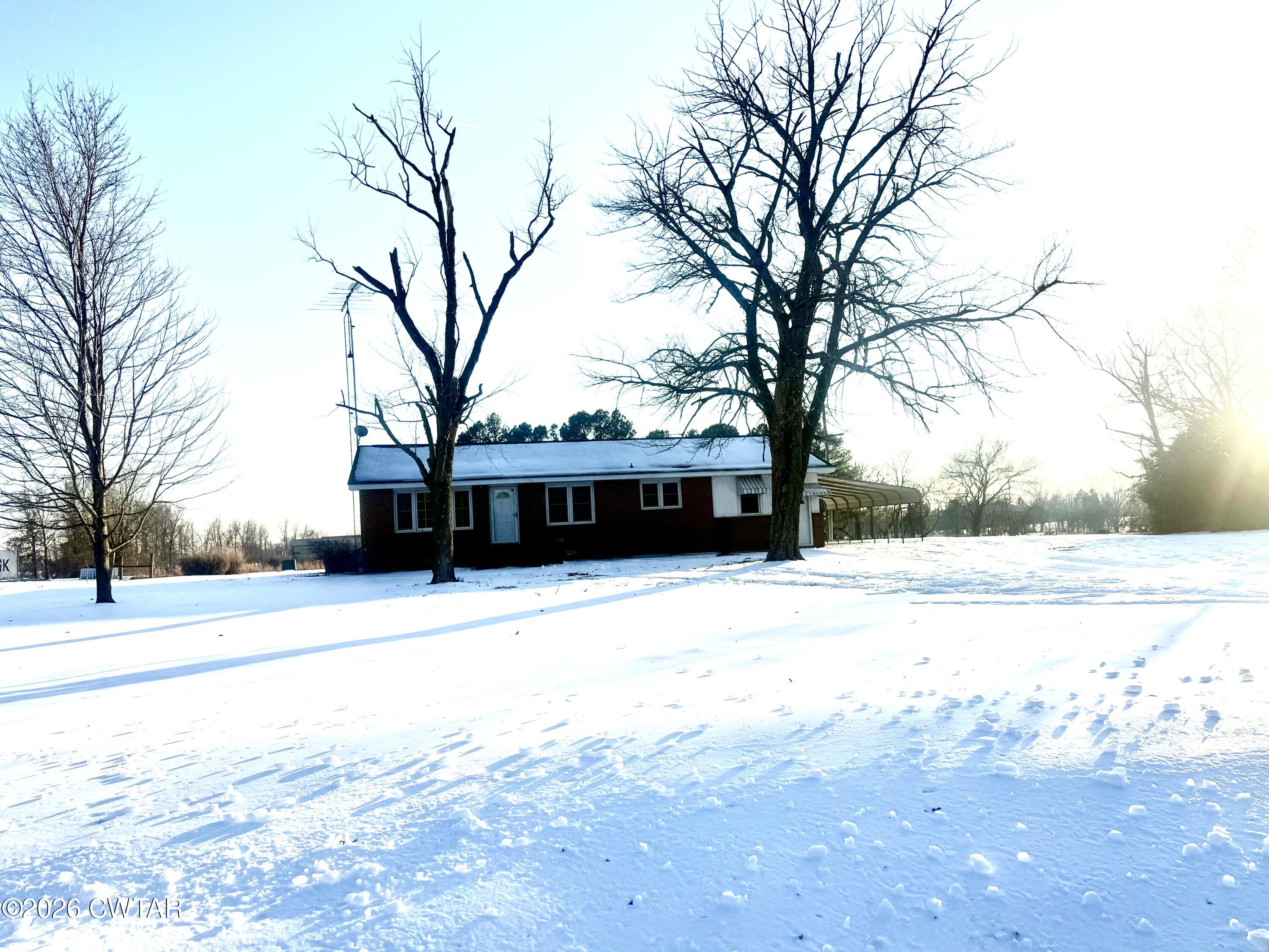 5389 Rives Mt Pelia Road Rives, TN 38253 - Photo 2 of 19 a view of a large white house with a yard covered with snow and trees