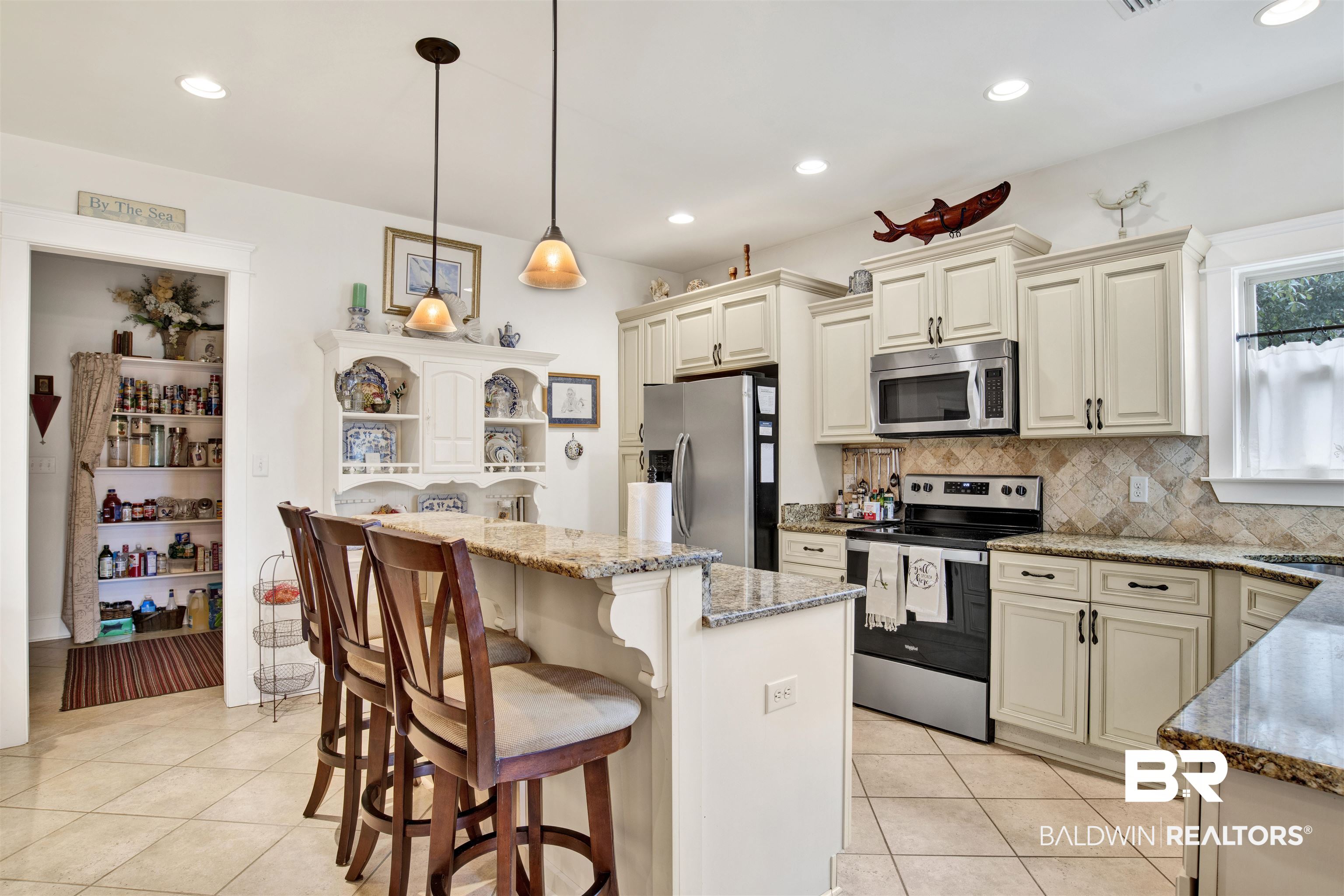 9240 Bay Point Drive Elberta, AL 36530 - Photo 11 of 22 Kitchen featuring a center island, stone counters, decorative light fixtures, stainless steel appliances, and cream cabinetry
