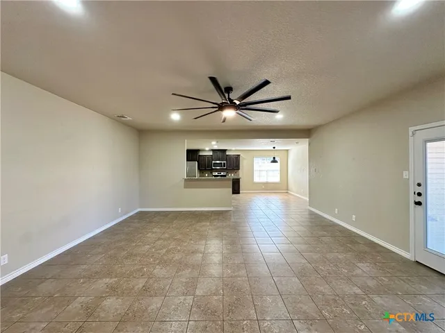 a view of a livingroom with a ceiling fan and wooden floor