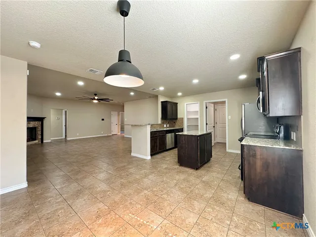 a kitchen with stainless steel appliances a refrigerator and a stove top oven