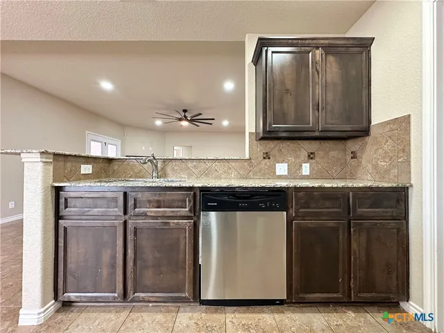 a kitchen with stainless steel appliances granite countertop a refrigerator stove and sink