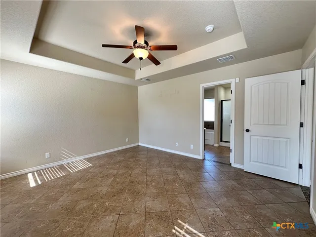 an empty room with a ceiling fan and a window