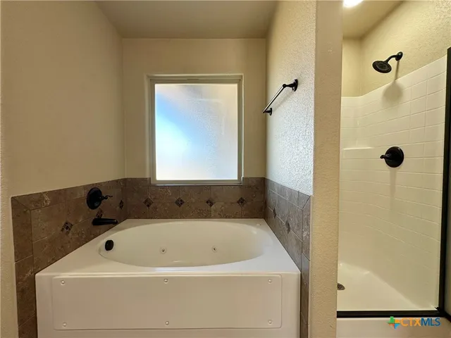a spacious bathroom with a double vanity sink a mirror and a bathtub