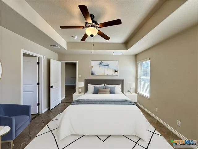 a bedroom with a large bed and a ceiling fan