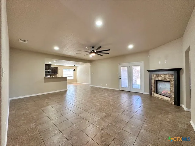 an empty room with windows and fireplace