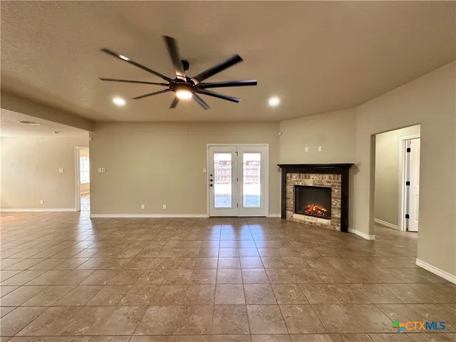 a view of an empty room with a fireplace and a window