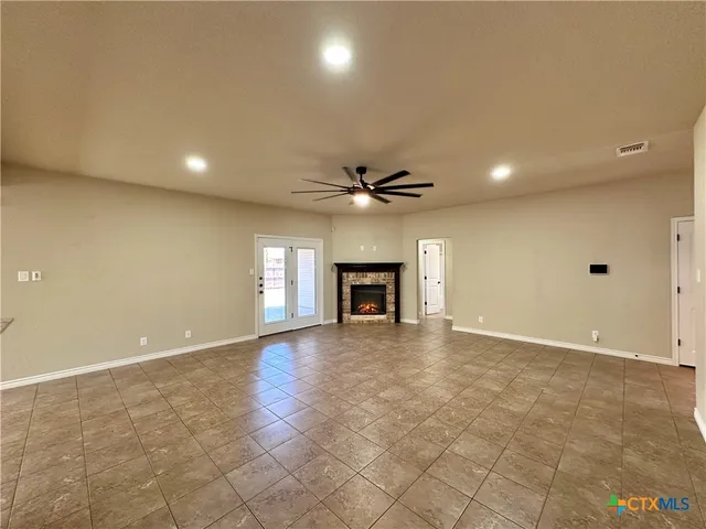 an empty room with windows and fireplace