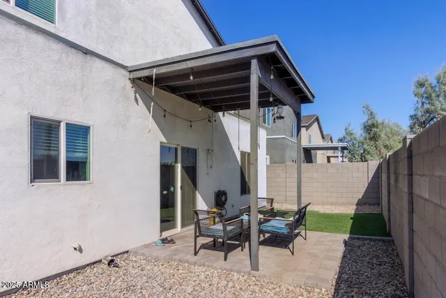 a view of a chair and table in backyard of the house