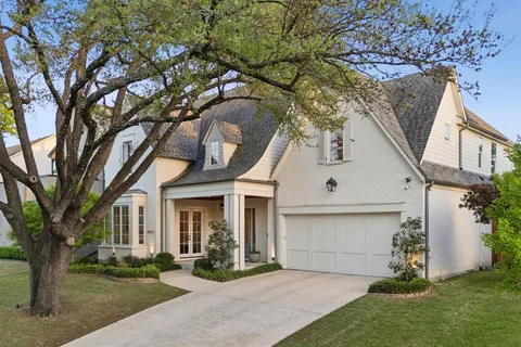 a front view of a house with a garden and trees