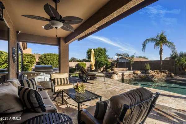 a view of a house with backyard water fountain and sitting area