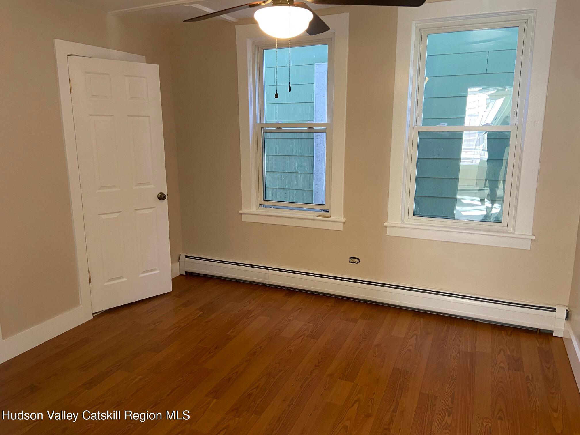 214 Robinson Street, Unit 2 Hudson, NY 12534 - Photo 2 of 13 an empty room with wooden floor and windows