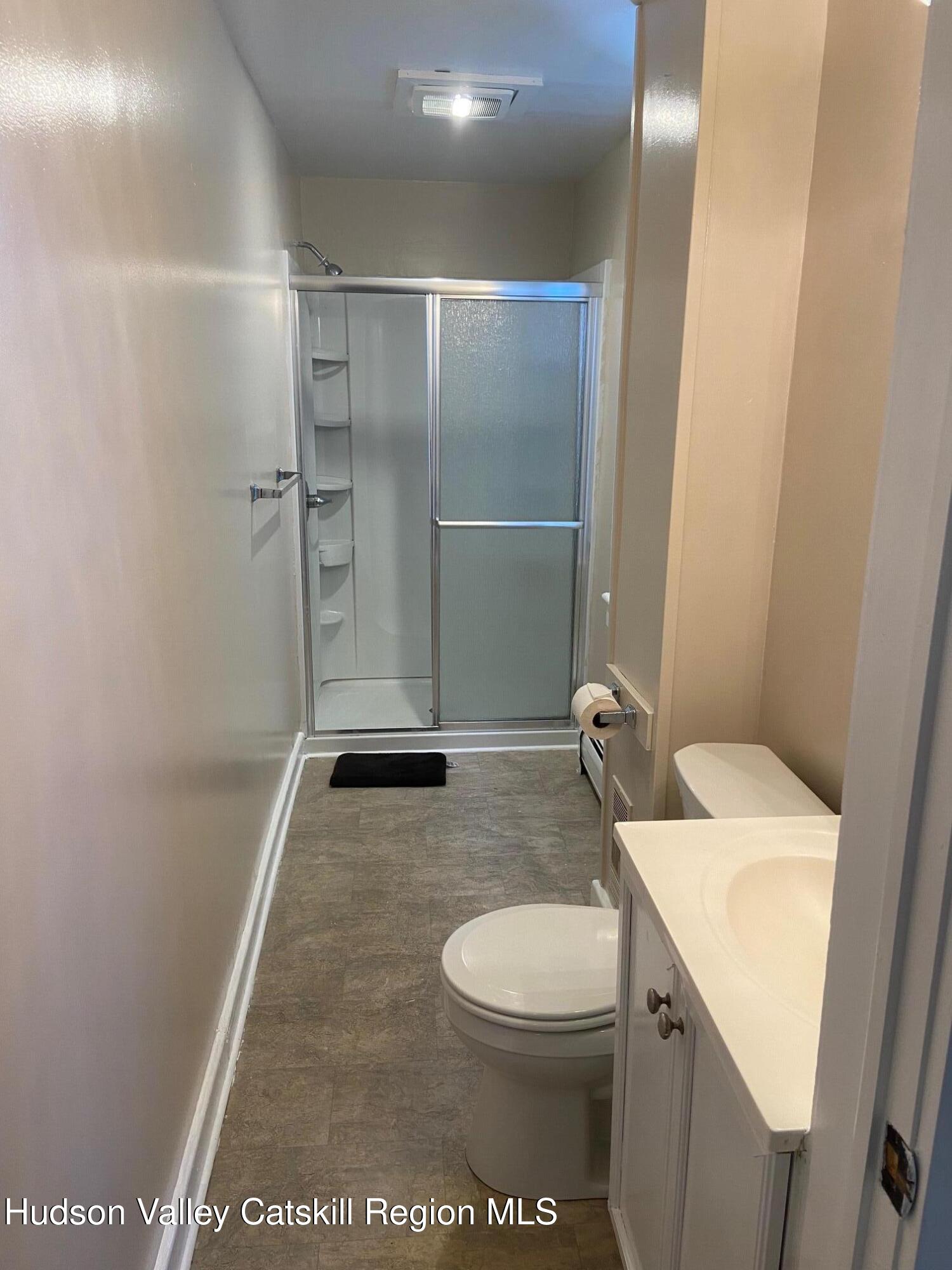 214 Robinson Street, Unit 2 Hudson, NY 12534 - Photo 9 of 13 a bathroom with a sink a toilet and a mirror