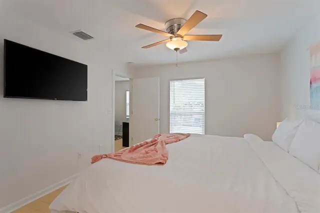 a bedroom with a large bed and a flat screen tv