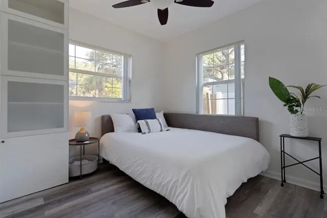 a bed sitting in a bedroom next to a window