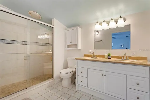 a bathroom with a double vanity sink mirror and toilet