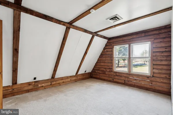 a view of an empty room and a bathroom with mirror