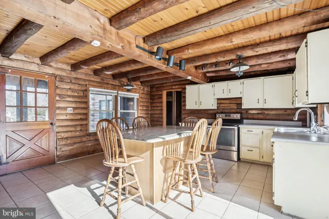 a view of a kitchen with a dining table and chairs