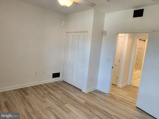 a view of an empty room with wooden floor